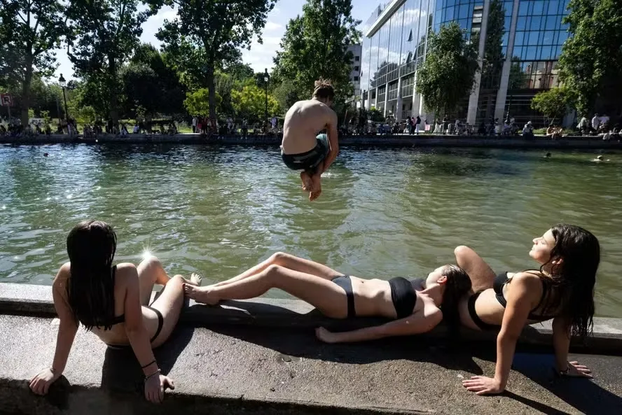Jovem salta em canal de Paris durante onda de calor na França; expectativa é que termômetros marquem até 40ºC no domingo — Foto: Joel Saget/AFP
